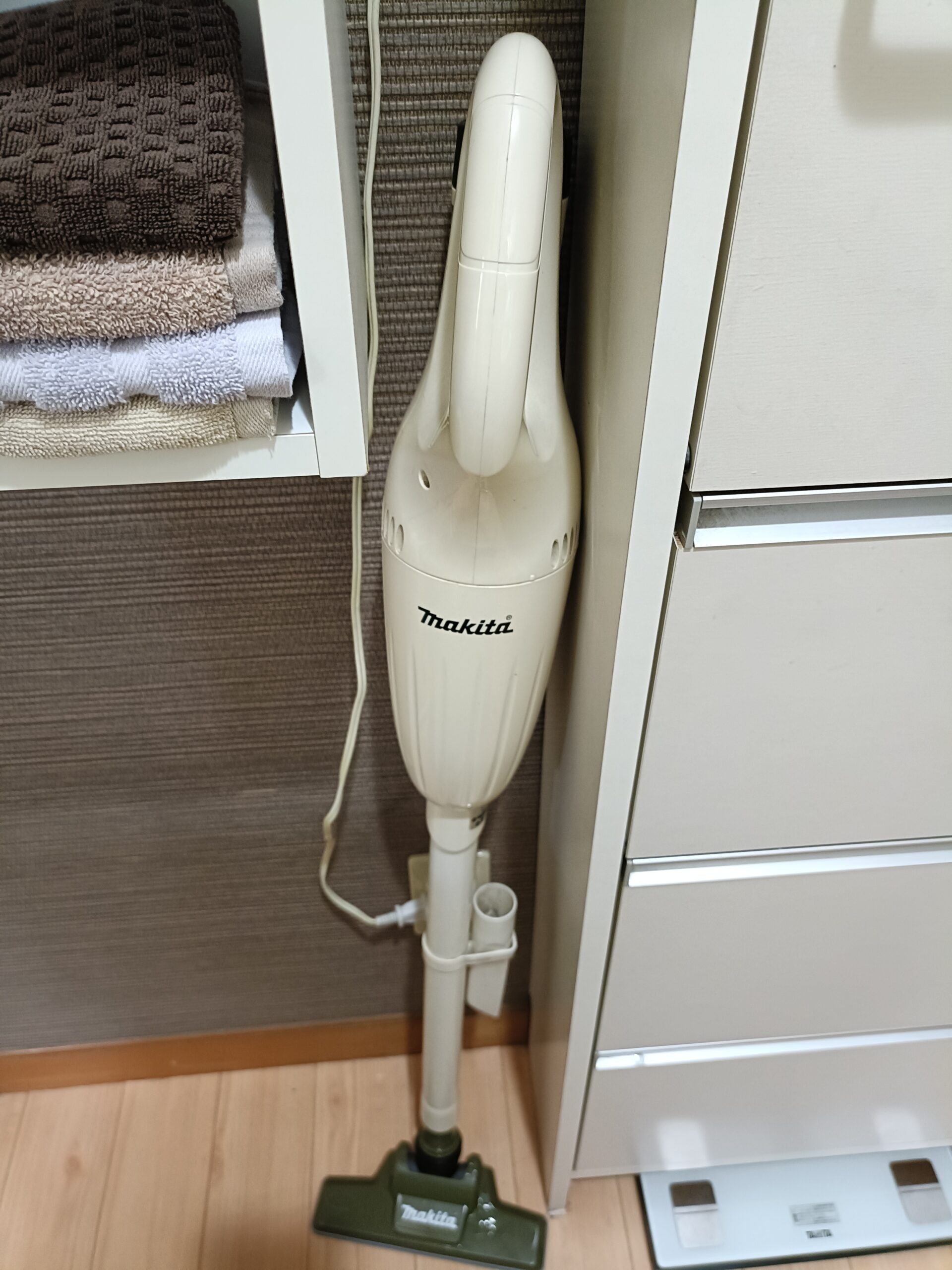 洗面所の家具の間に立てかけたマキタコードレスクリーナー