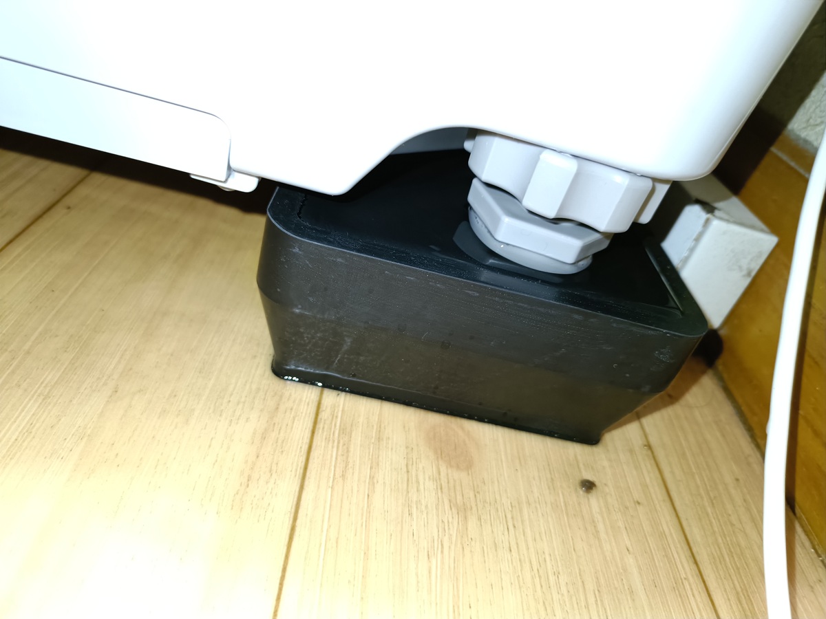 かさ上げ台に水が溜まっている洗濯機の足元の写真