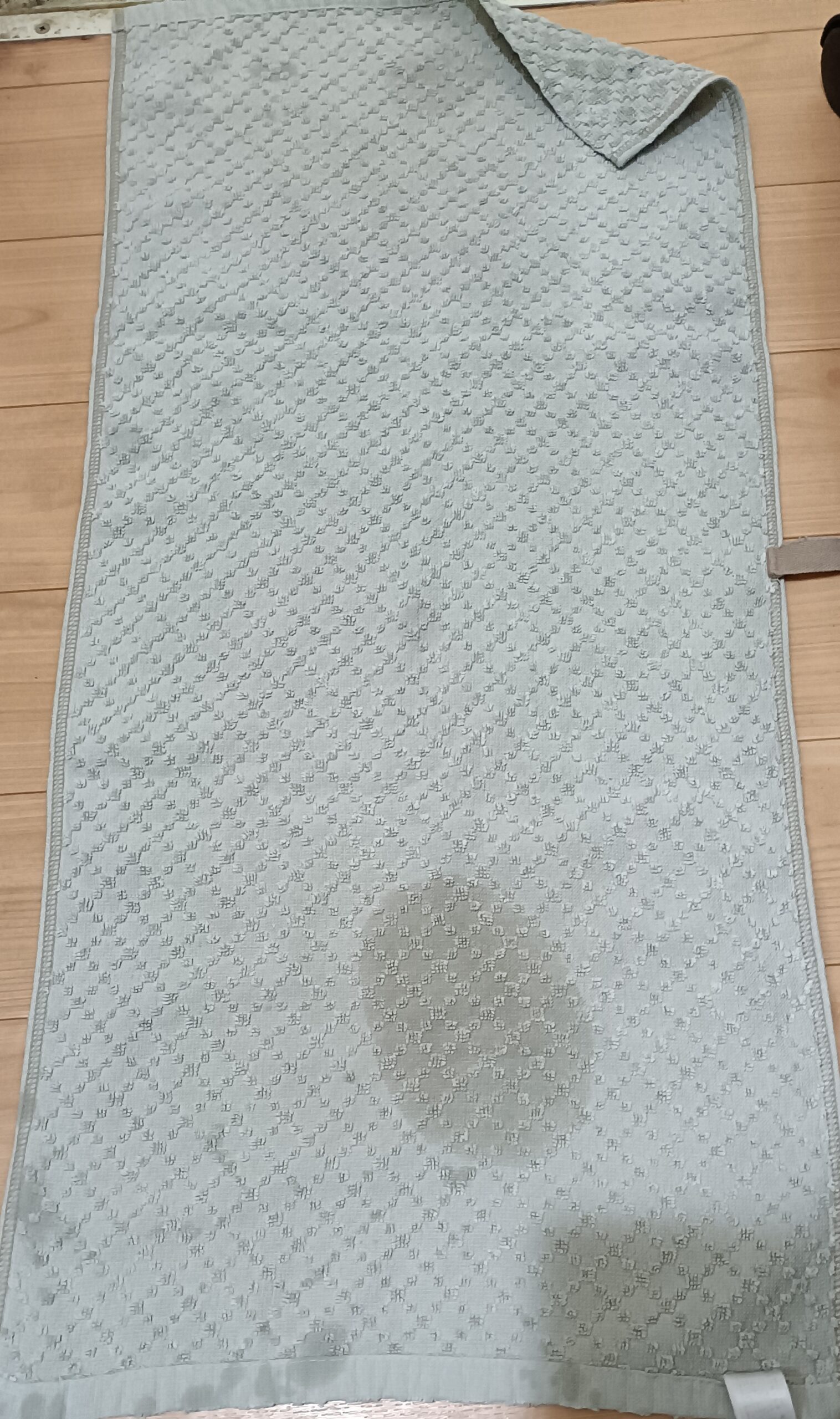 洗濯機の足元で水漏れを受け止めたタオルの写真